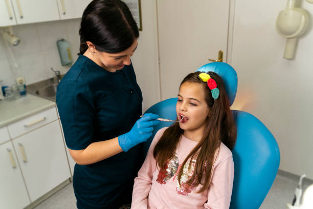 dentist examining little girl teeth health