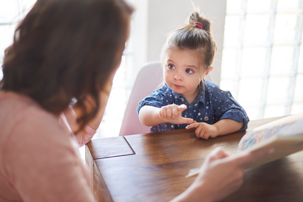 cute girl with mom reading book